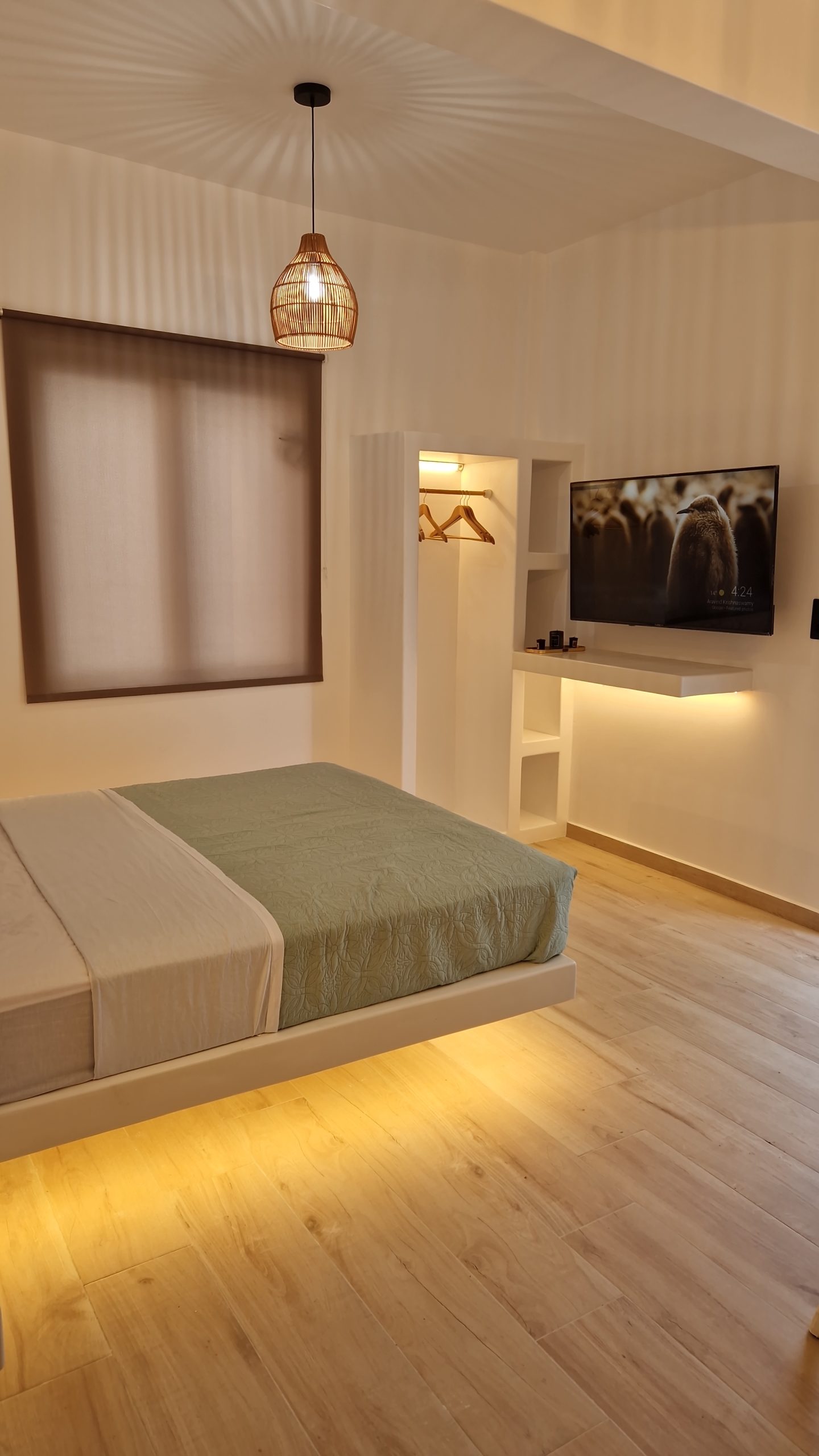 Actual Alya Paros bedroom with woven pendant light, soft green linen and wooden details
